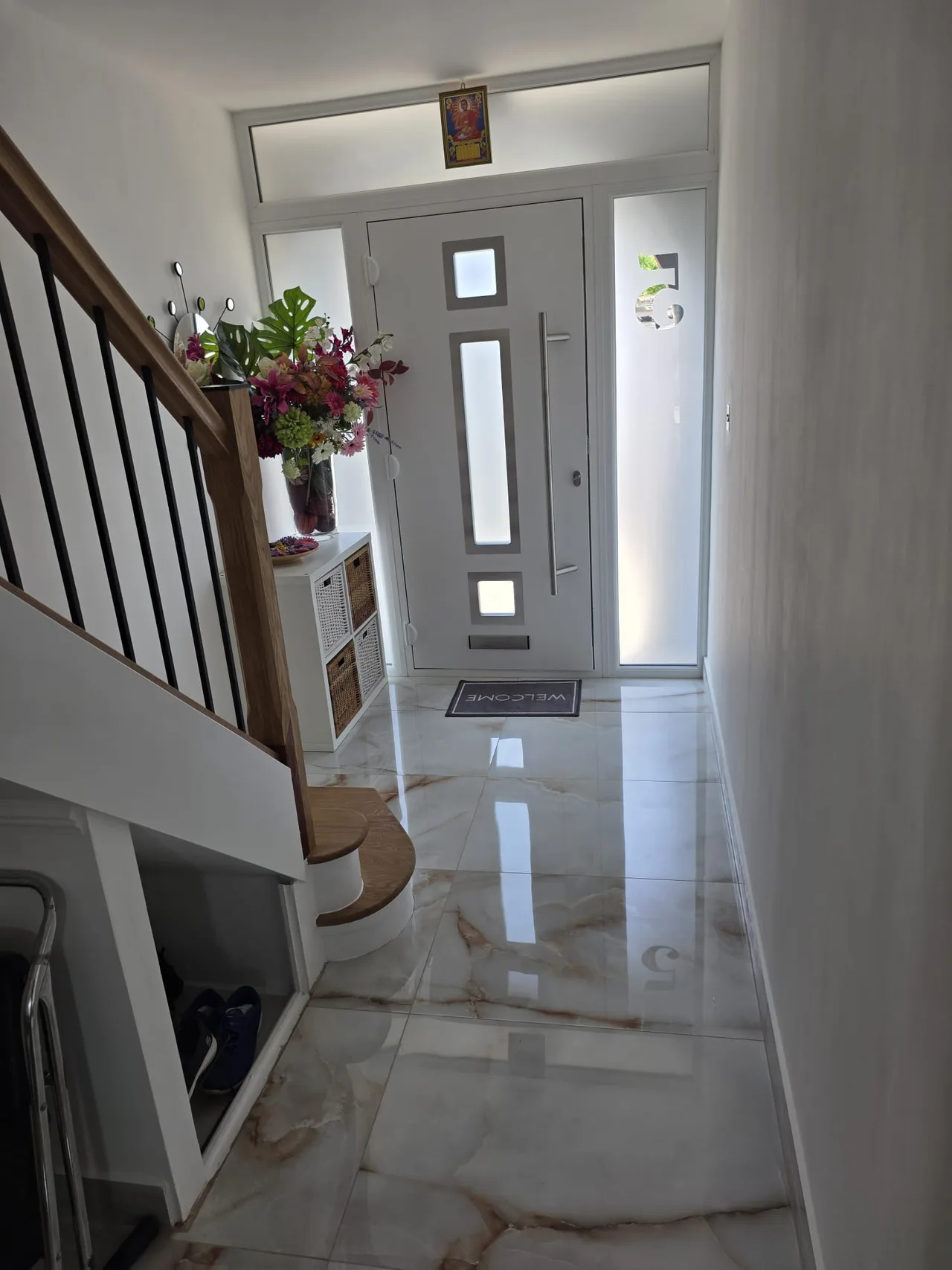 Light hallway flooring and a timber staircase