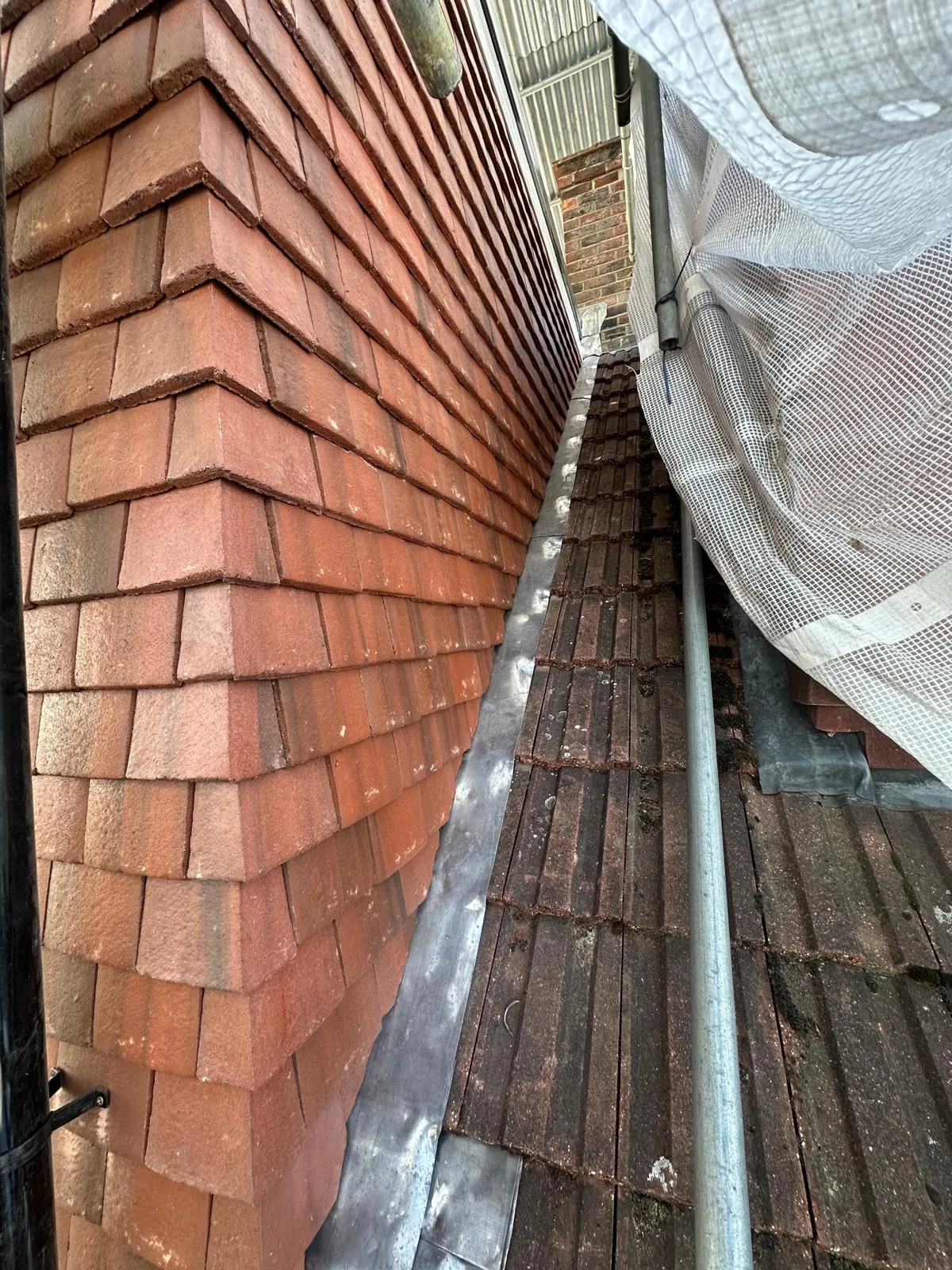 Close-up of roof tiles alongside scaffolding