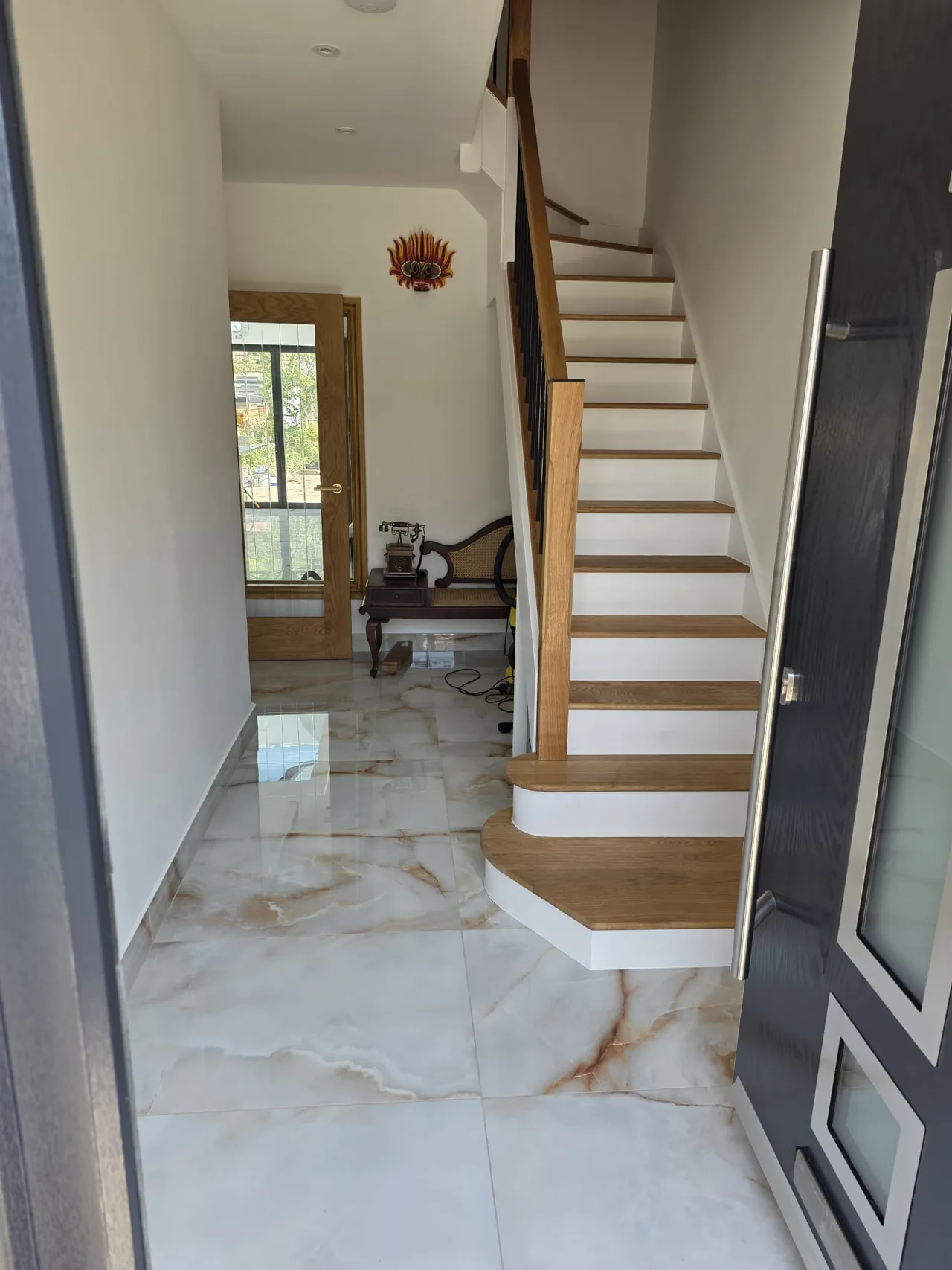 Timber staircase and bright hallway with stone-effect flooring